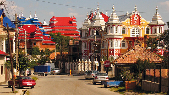 VÁROSKÉP-ZAVAR – A nagy átmenő forgalmú vidéki kisváros telkein mintha megannyi cizellált ugrálóvárat fújtak volna föl hirtelen. Távolról... Közelről azonban levegőt sem engednek a hagyományos épületeknek — uralják a légteret Fotó: Erdélyi Eszkimó Péter